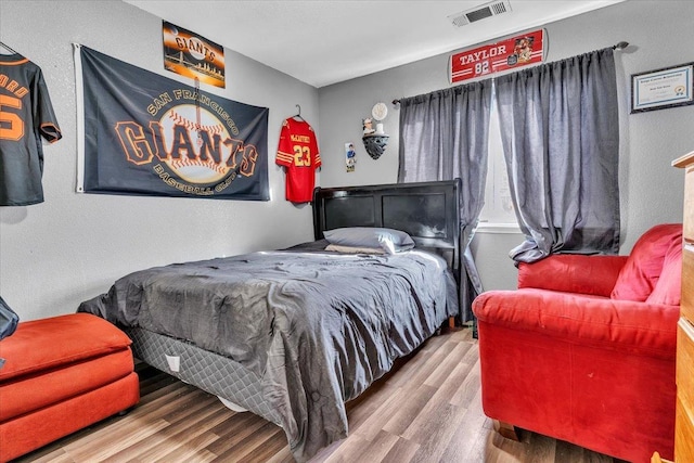 bedroom with visible vents and wood finished floors