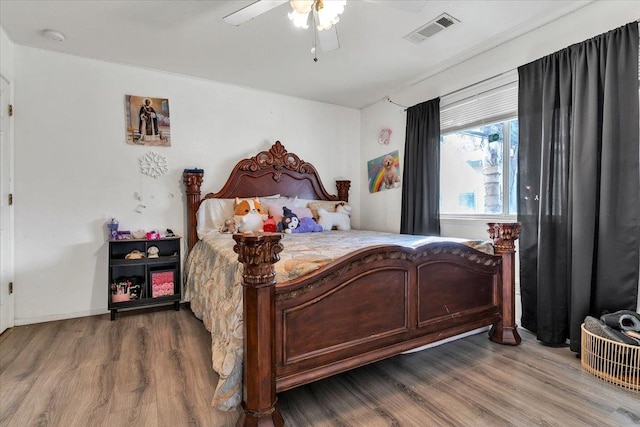 bedroom with visible vents, a ceiling fan, and wood finished floors