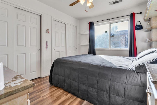 bedroom featuring a ceiling fan, light wood-style floors, and visible vents