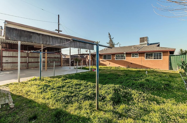 view of yard with central air condition unit, fence, and a patio area