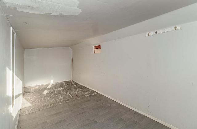 unfurnished room featuring lofted ceiling and wood finished floors