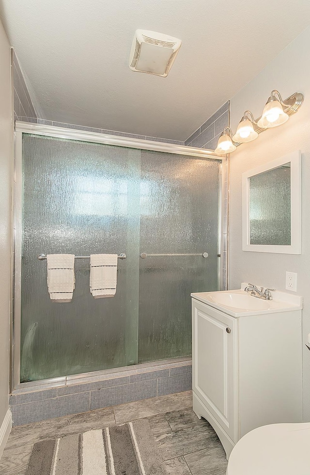 bathroom with a stall shower and vanity