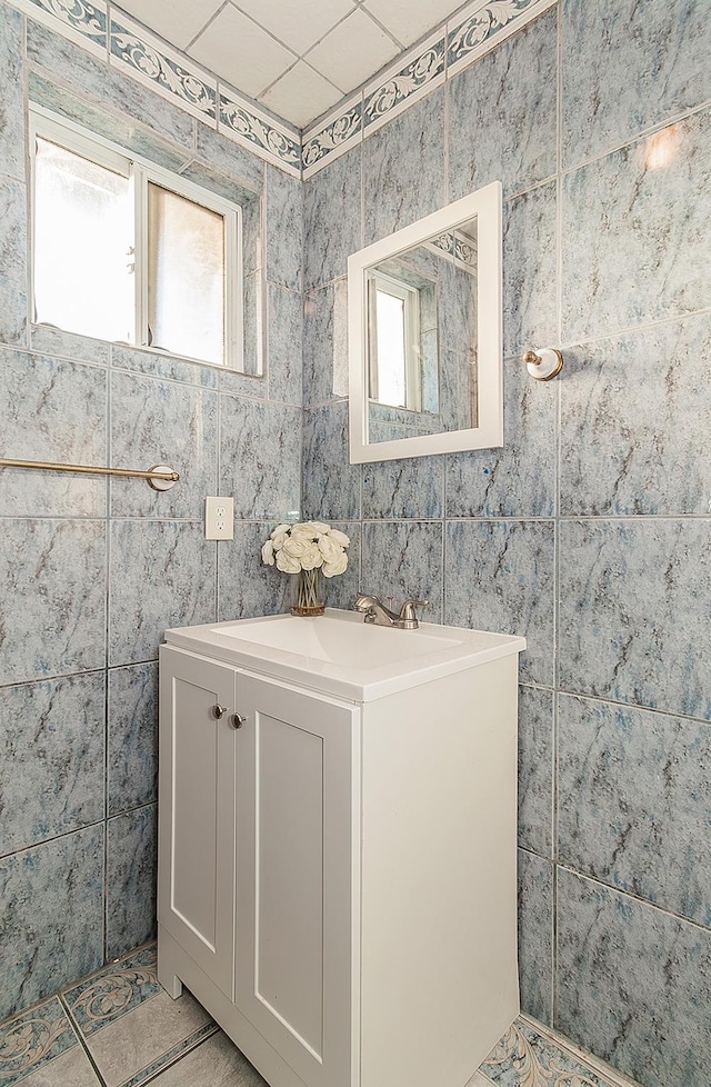 bathroom featuring vanity and tile walls