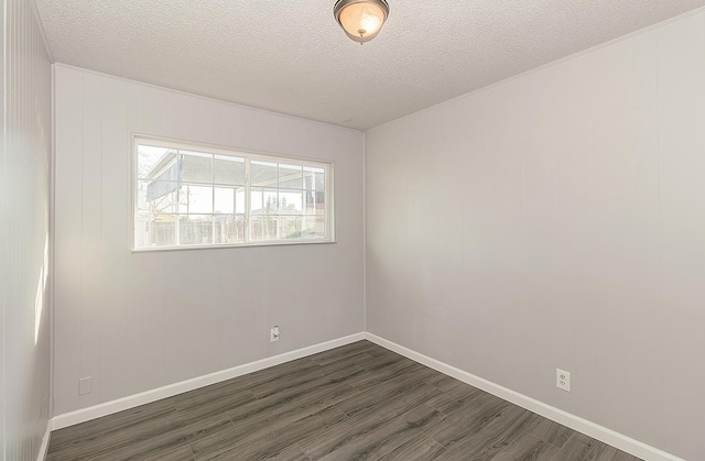 unfurnished room with baseboards, a textured ceiling, and dark wood-style flooring