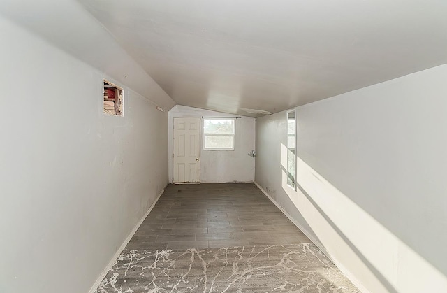 corridor with lofted ceiling and wood finished floors