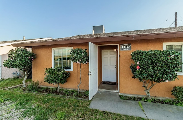 view of exterior entry with stucco siding