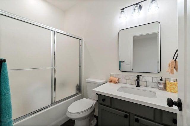 bathroom featuring vanity, toilet, and shower / bath combination with glass door