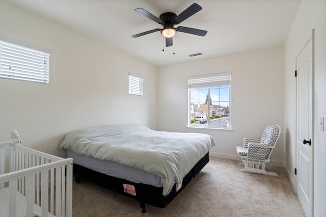 bedroom featuring carpet flooring, multiple windows, baseboards, and visible vents