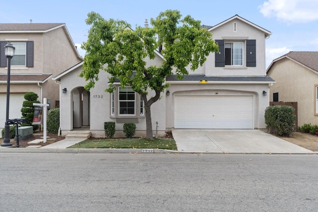 traditional-style house with stucco siding, concrete driveway, and an attached garage