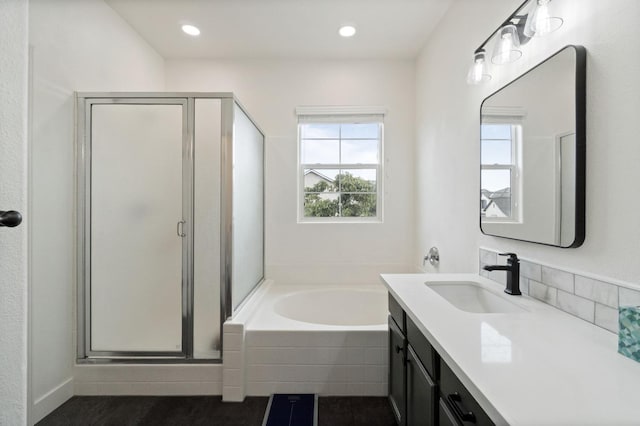 full bathroom featuring a bath, recessed lighting, a stall shower, and vanity