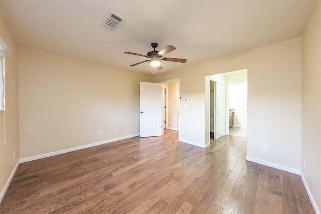 interior space with ceiling fan, wood finished floors, visible vents, and baseboards