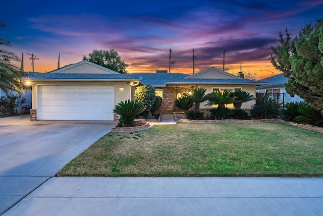 ranch-style house with a garage, stucco siding, concrete driveway, and a front lawn