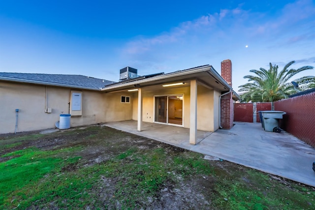 back of property featuring fence, central air condition unit, stucco siding, a chimney, and a patio area