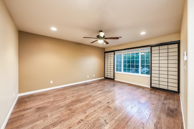 empty room featuring recessed lighting, a ceiling fan, baseboards, and wood finished floors