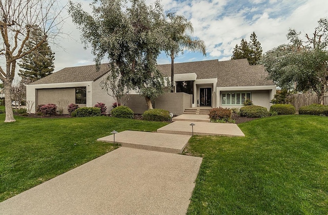 view of front of home featuring a front yard, fence, and stucco siding