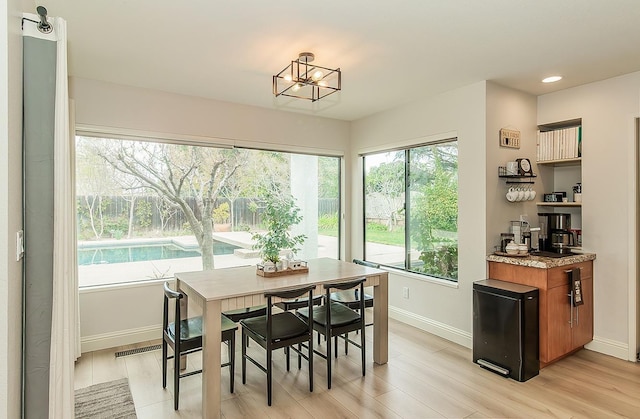 dining space with light wood finished floors, recessed lighting, an inviting chandelier, and baseboards