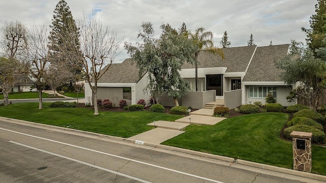 view of front of property featuring stucco siding and a front lawn