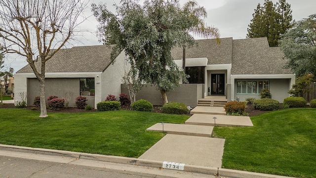 view of front facade featuring stucco siding and a front yard