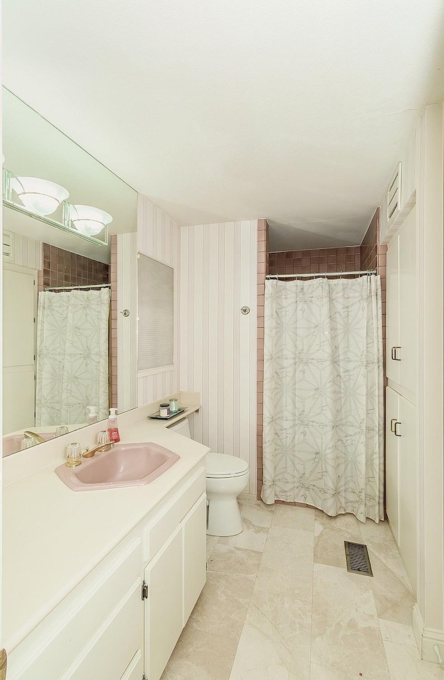 bathroom featuring vanity, toilet, a shower with curtain, and visible vents