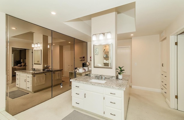 ensuite bathroom featuring two vanities, recessed lighting, ensuite bathroom, and a sink