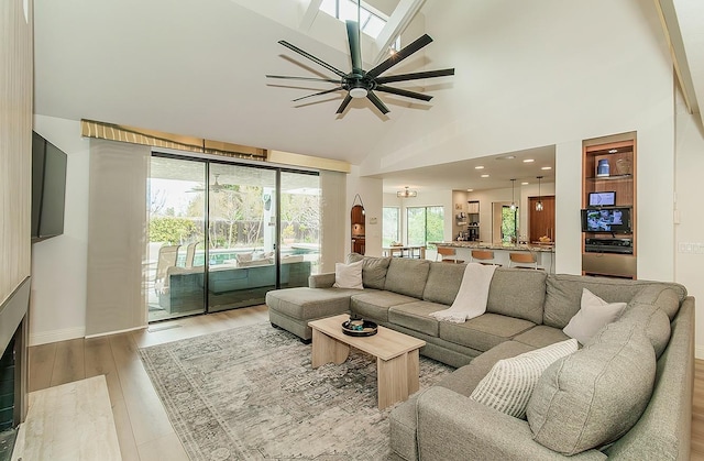 living room with light wood-style flooring and high vaulted ceiling