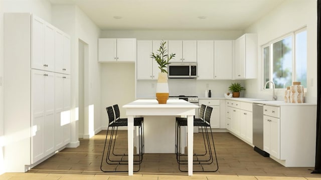 kitchen featuring a sink, light wood-style floors, dishwasher, and white cabinetry