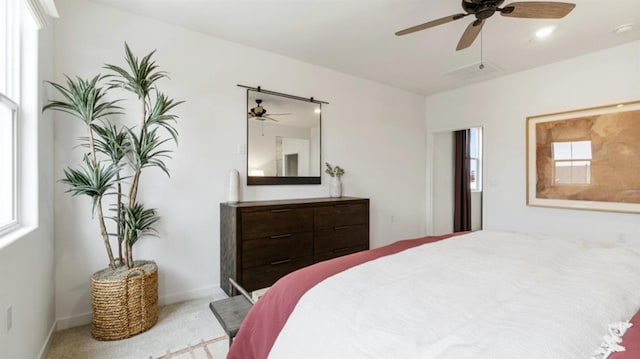 carpeted bedroom with baseboards, visible vents, multiple windows, and a ceiling fan