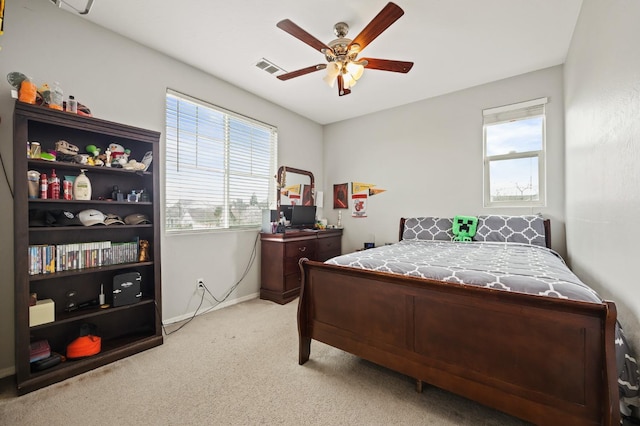 bedroom featuring multiple windows, a ceiling fan, baseboards, and light carpet