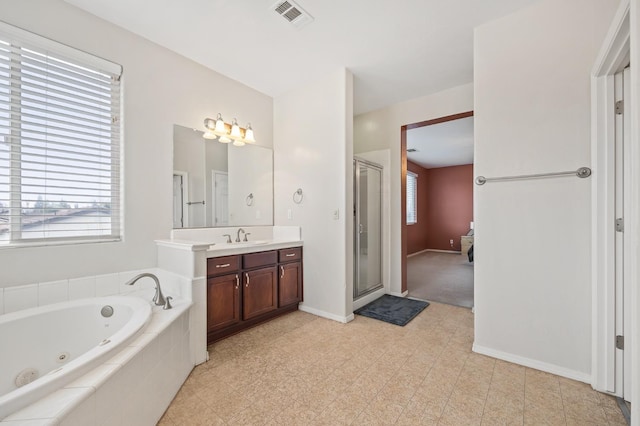 bathroom with visible vents, plenty of natural light, a whirlpool tub, a shower stall, and vanity