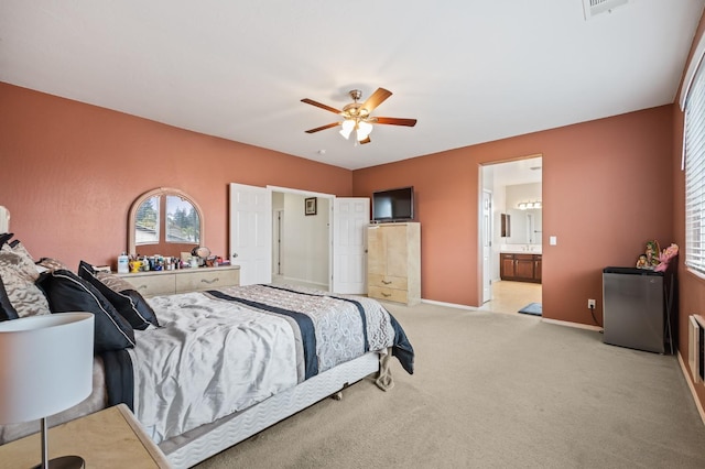 bedroom featuring a ceiling fan, visible vents, baseboards, refrigerator, and light colored carpet