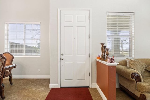 tiled foyer featuring baseboards