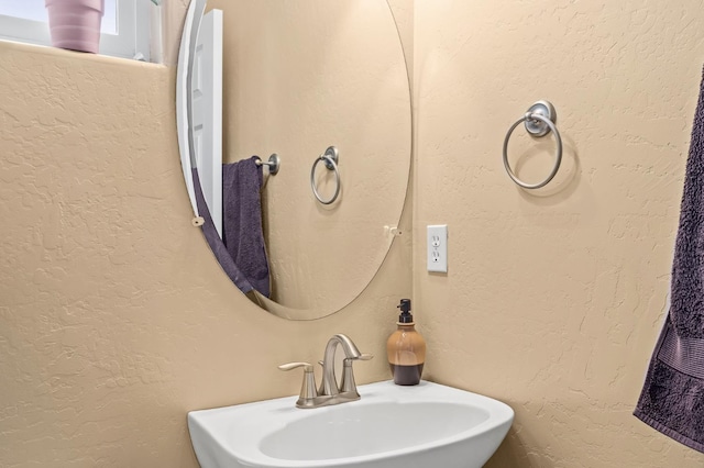 bathroom featuring a sink and a textured wall