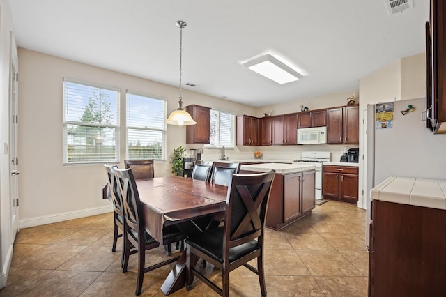 dining space with light tile patterned flooring, visible vents, and baseboards