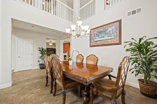 dining area featuring visible vents, baseboards, light tile patterned floors, a towering ceiling, and a notable chandelier