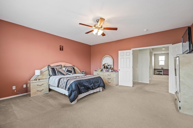 bedroom featuring baseboards, light colored carpet, and a ceiling fan