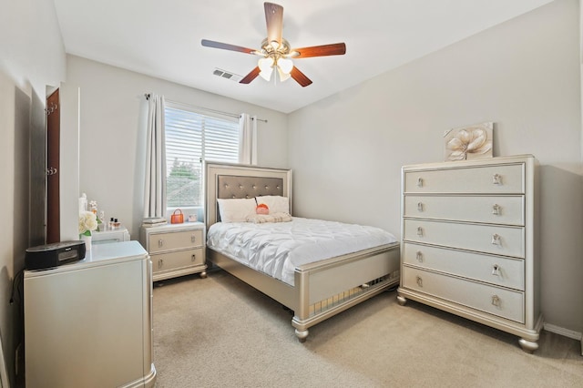 bedroom featuring visible vents, light colored carpet, and ceiling fan