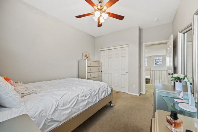 bedroom featuring a ceiling fan, baseboards, a closet, and light carpet