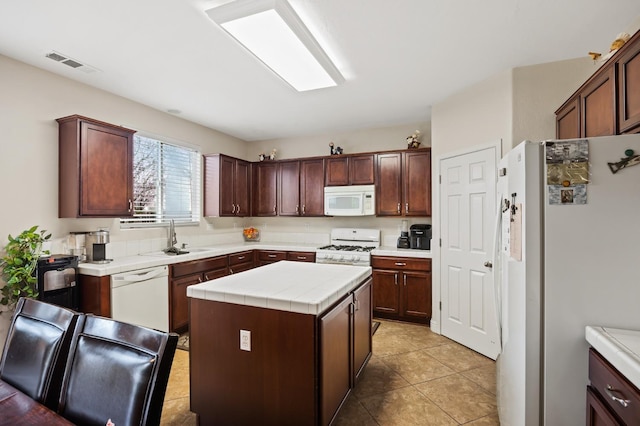 1410 Azalea St, Kingsburg, CA 93631 - kitchen featuring white appliances, tile countertops, a kitchen island, light tile patterned flooring, and dark brown cabinetry
