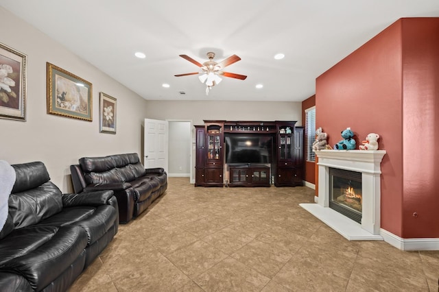 living area with a glass covered fireplace, recessed lighting, and baseboards