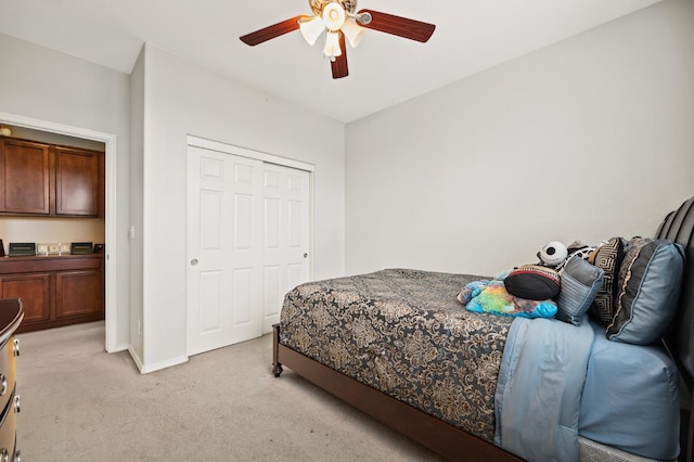 bedroom with ceiling fan, baseboards, a closet, and light carpet