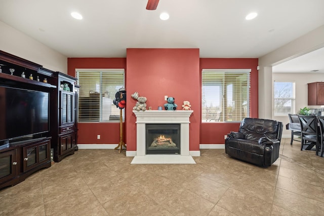 living area with recessed lighting, baseboards, and a lit fireplace