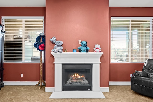 living room featuring baseboards and a glass covered fireplace