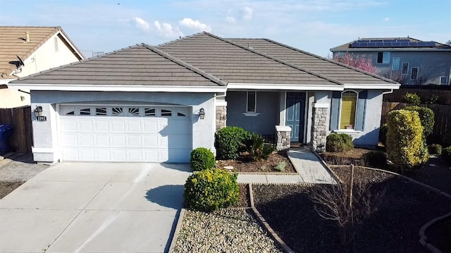 ranch-style home featuring a garage, stucco siding, driveway, and a tiled roof