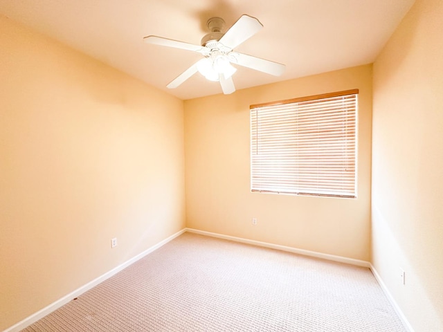 empty room with light colored carpet, baseboards, and ceiling fan