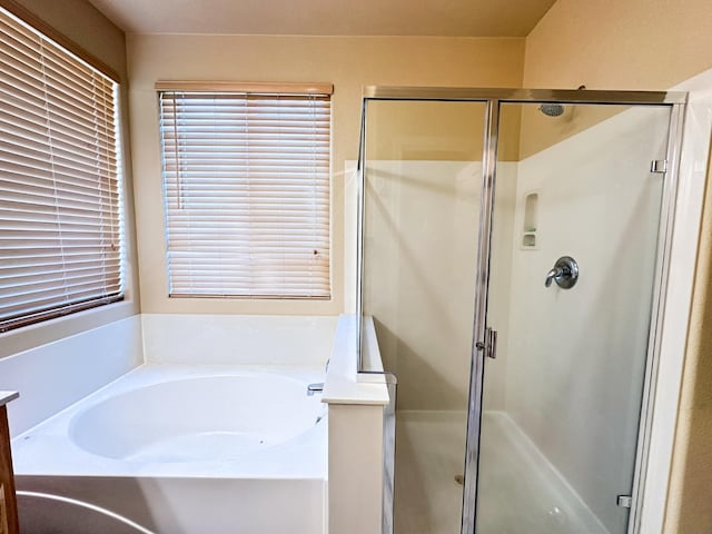 full bathroom featuring a garden tub and a shower stall