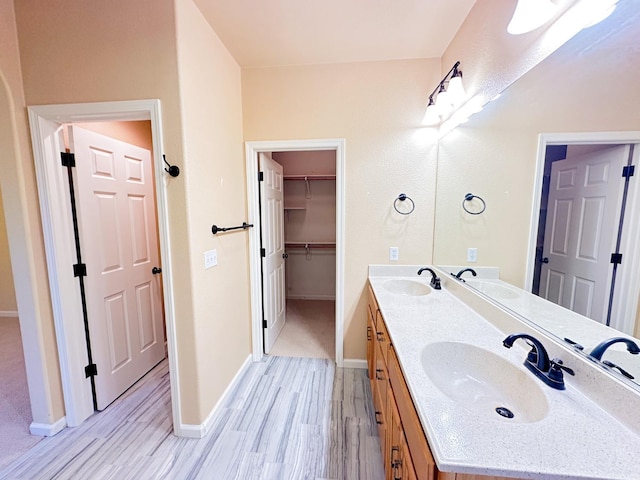 bathroom with double vanity, wood finished floors, and a sink