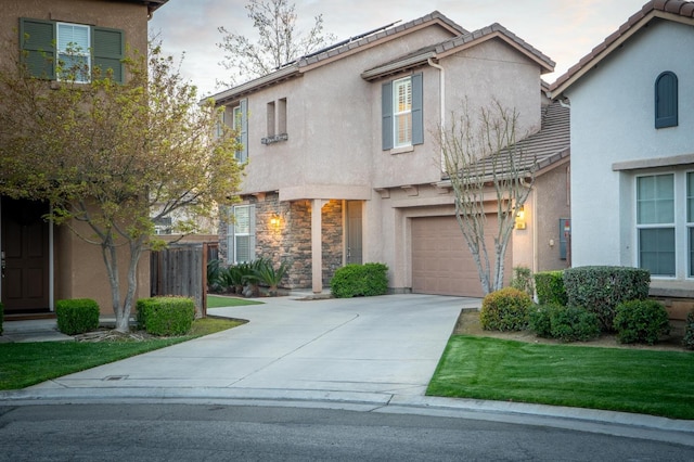 view of front of house with stucco siding, a tiled roof, concrete driveway, and an attached garage