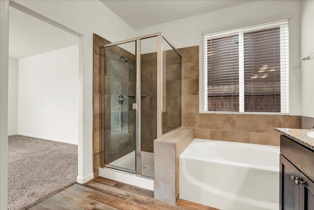 full bathroom featuring vanity, a garden tub, wood finished floors, and a shower stall