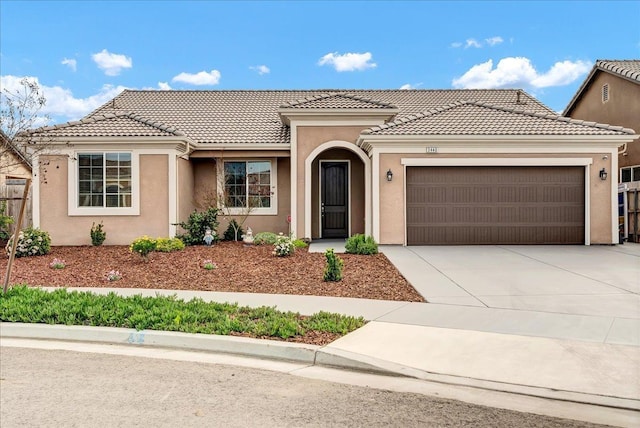 view of front facade with a garage, stucco siding, driveway, and a tiled roof