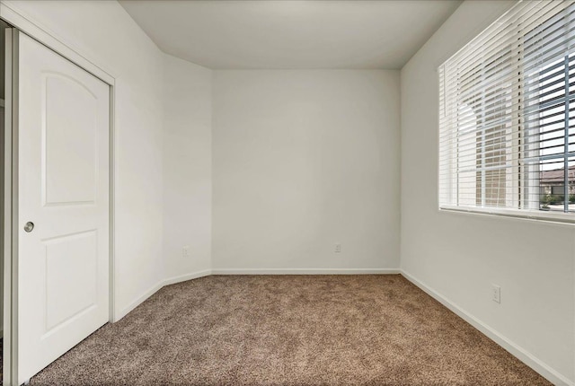 spare room with carpet flooring and baseboards